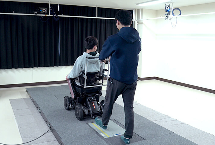 センサーを埋め込んだ床で通常の歩行と電動椅子で引っ張ったときとの踏力を計測する